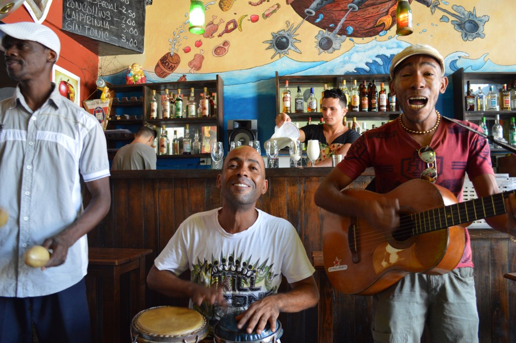Guantanamera, 2016 Photograph A lively representation of Cuban culture. Three musicians in a restaurant singing a well-known song called “Guantanamera.” The song was originally a poem written by Jose Martí.